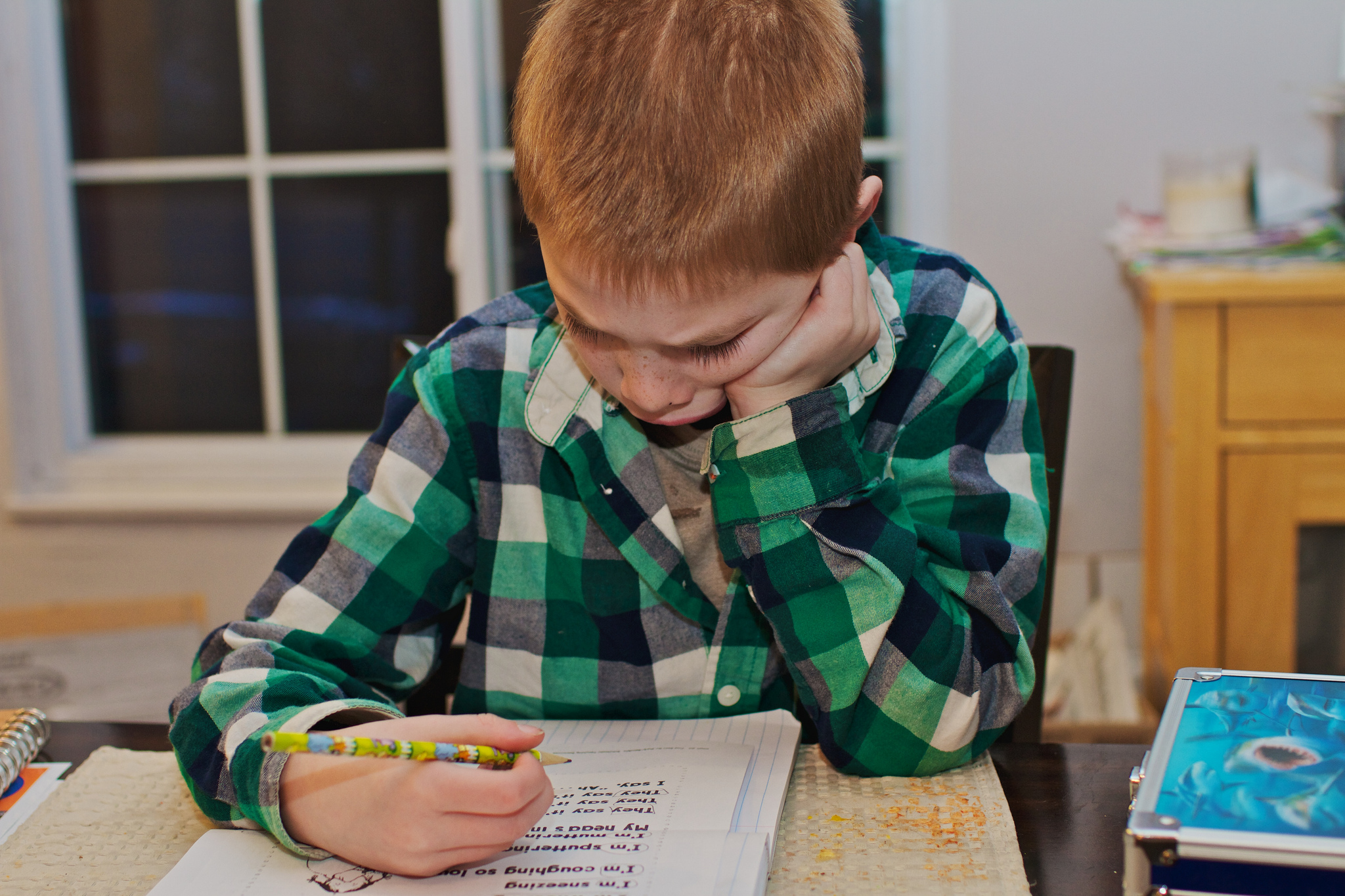copil scriind temele pentru acasa
